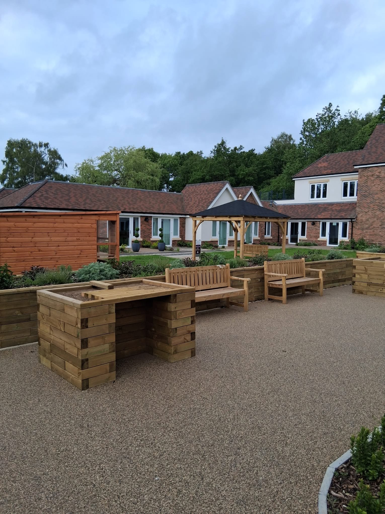 Resin courtyard with timber planters and benches
