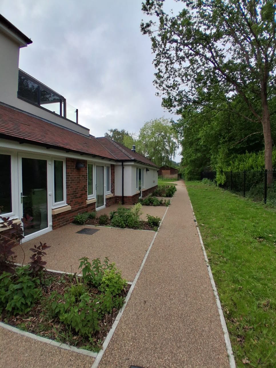 Resin path running along the side of a building with planting