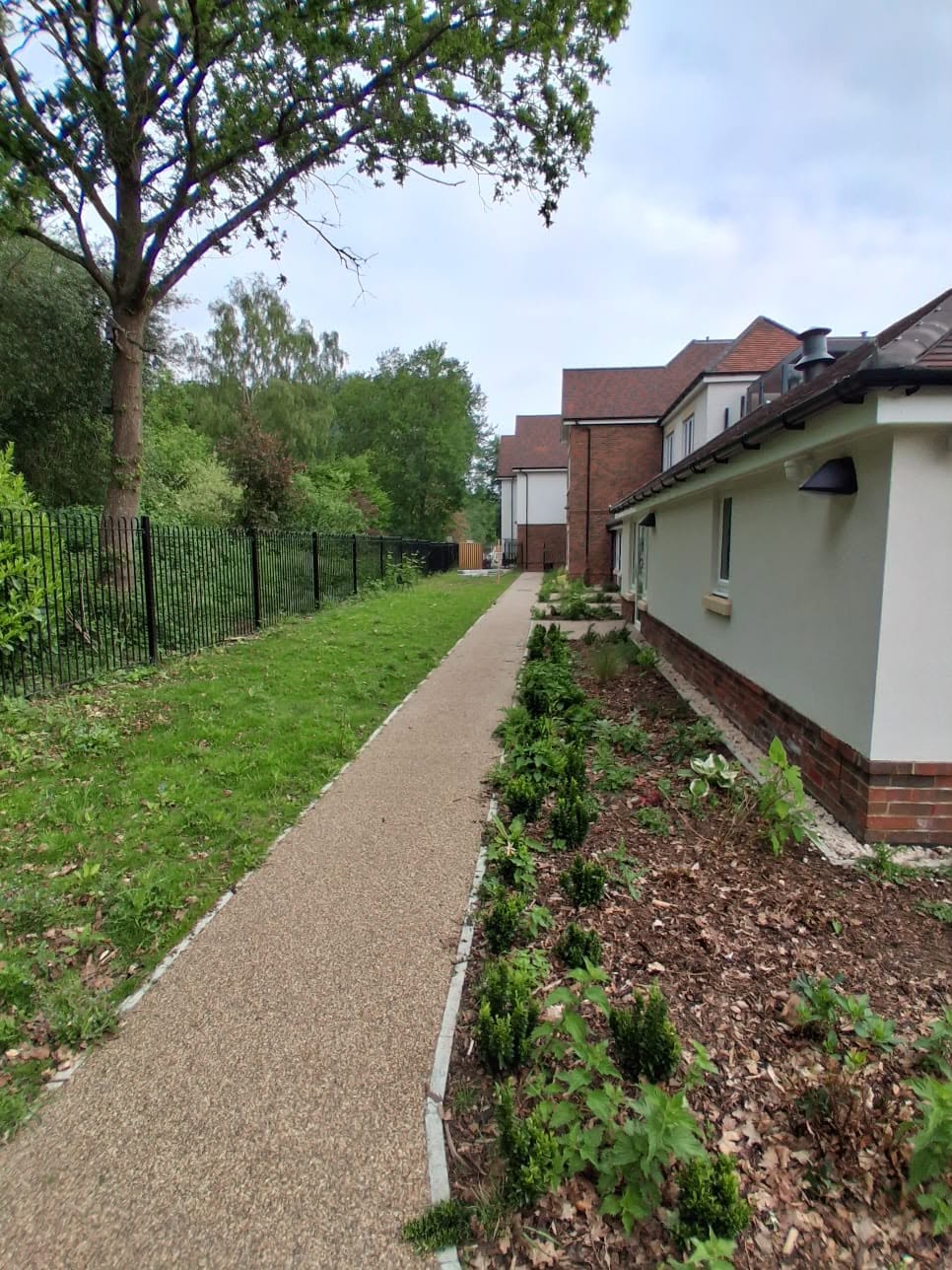 Resin path between a building and a new fence line