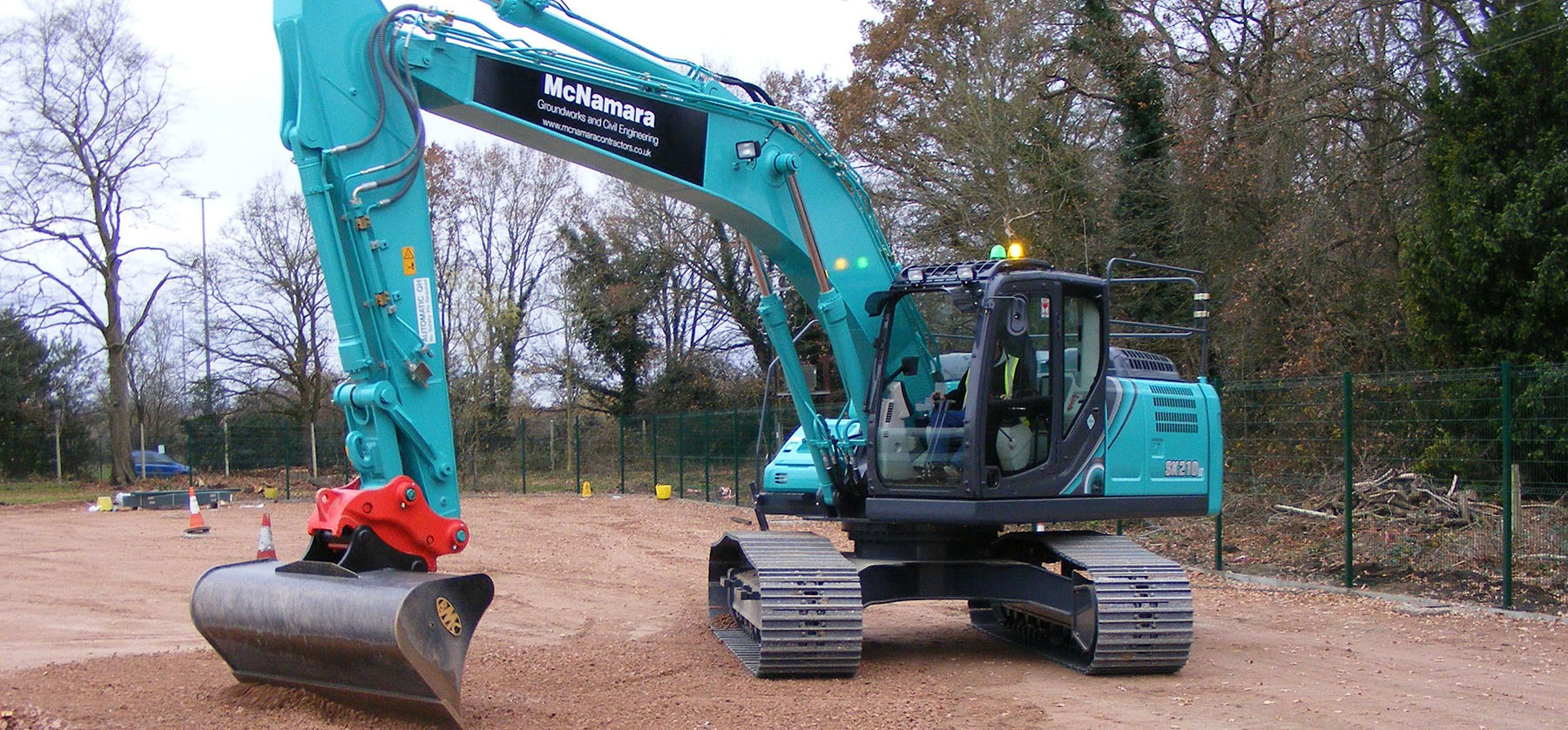McNamara-branded excavator on a cleared site ready for groundworks
