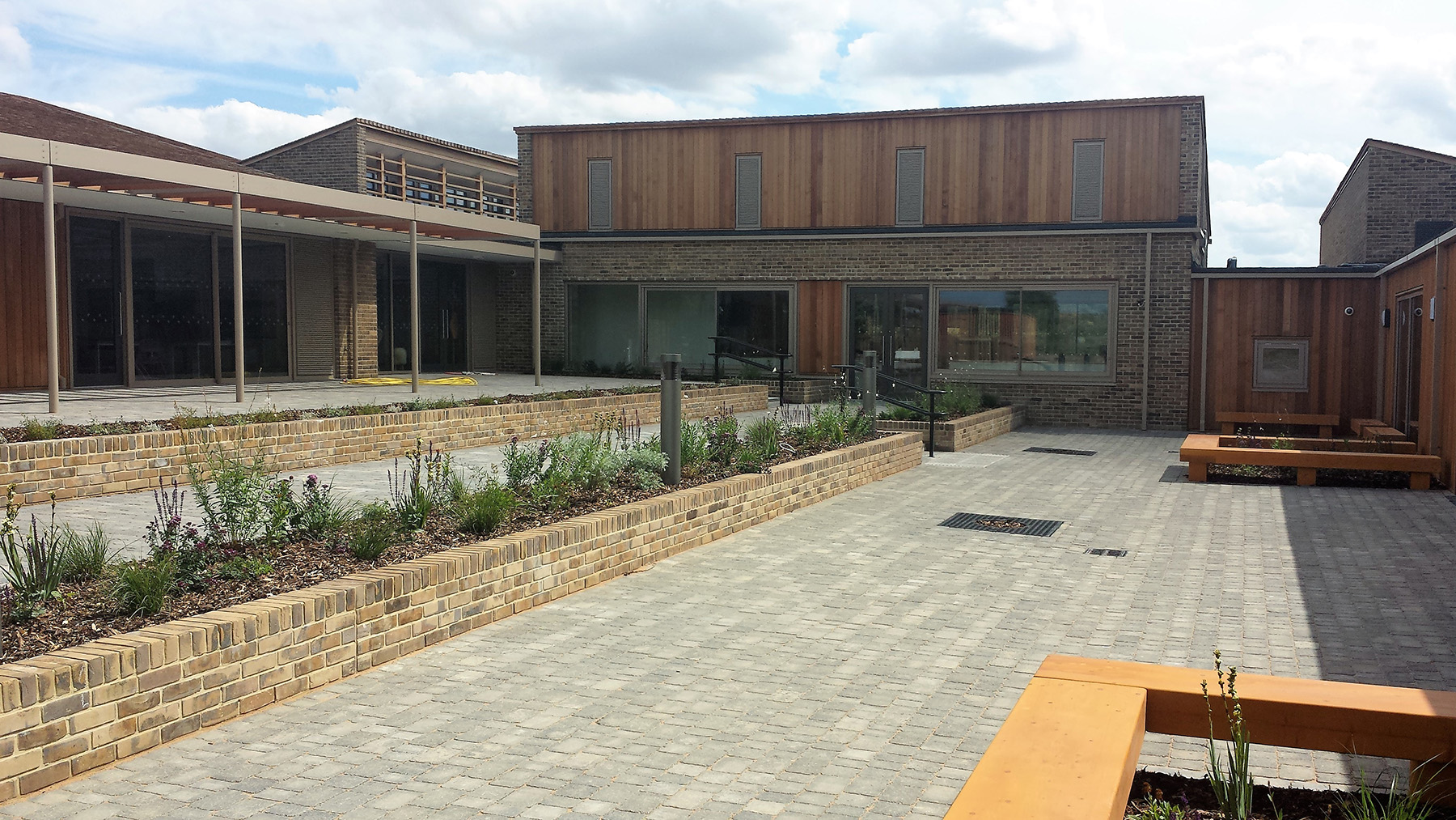 Block-paved courtyard with brick raised planters outside Pilgrims Cross School, Andover